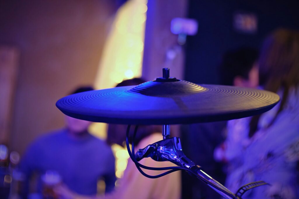 People playing drums playing live music in a pub house.